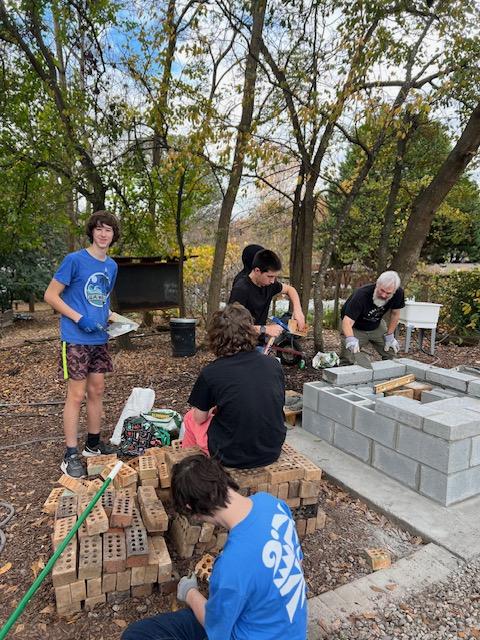 Students constructing a brick oven